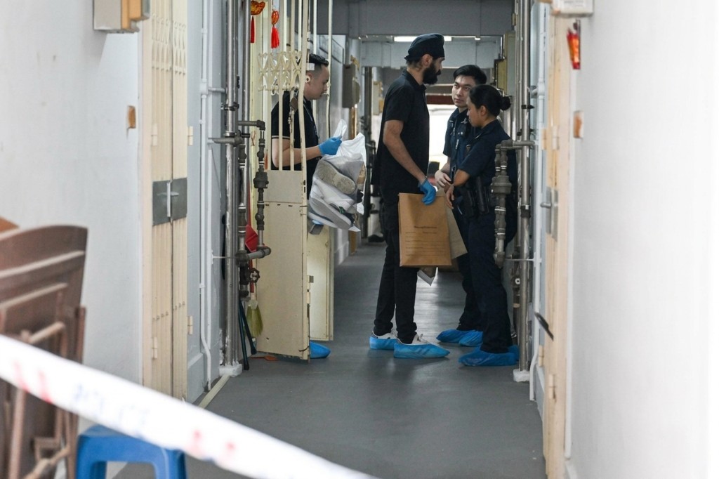 Investigators collecting evidence at a cordoned residential corridor